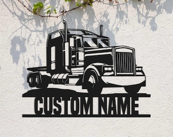 Op de afbeelding: Zwarte metalen silhouet van een vrachtwagen met de tekst "CUSTOM NAME" eronder. De vrachtwagen is naar de rechterkant van de afbeelding gericht.