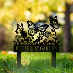 May include: Black metal garden stake with a butterfly garden sign. The sign features a silhouette of butterflies and flowers.