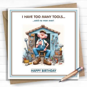 May include: A birthday card featuring a cartoon of an elderly man in a tool shed, holding a wrench. Text reads "I HAVE TOO MANY TOOLS...said no man ever!" and "HAPPY BIRTHDAY". The card is on a brown envelope, with a pencil in the foreground.