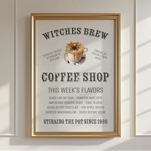 May include: A framed poster with a gold-coloured frame. The poster features the words "Witches Brew Coffee Shop" with a coffee cup graphic. The poster lists "This Week's Flavours" with spooky names. The text "Stirring the Pot Since 1930" is at the bottom.