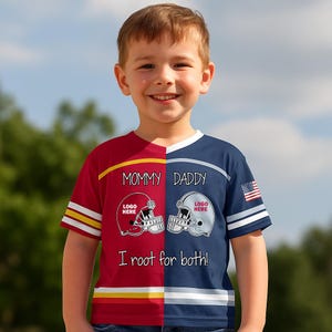 Może przedstawiać: Koszulka o dzielonym wzorze z czerwoną lewą stroną i niebieską prawą stroną. Tekst brzmi MOMMY DADDY oraz I root for both! z dwiema grafikami kasków futbolowych z napisem LOGO HERE. Na prawym rękawie znajduje się mała naszywka z flagą amerykańską.
