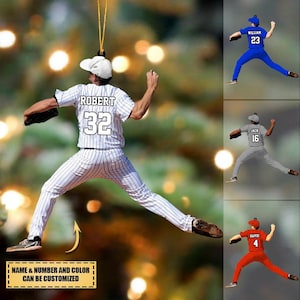 May include: Baseball-themed ornament depicting a player in a white and black pinstripe uniform with the name "ROBERT" and number "32". The text "NAME & NUMBER AND COLOR CAN BE CUSTOMIZED" is present. Other ornaments show players in blue, grey, and red uniforms.