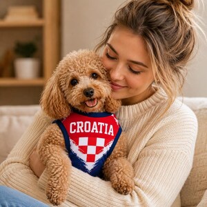 May include: A dog vest featuring a red, white, and blue color scheme with a checkered pattern and the word CROATIA printed in white capital letters across the chest. The garment has a dark blue trim around the neck and arm openings.