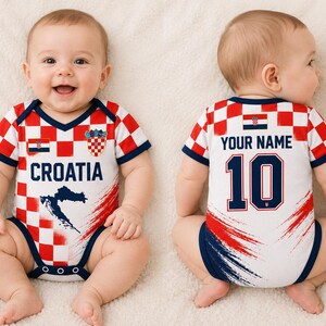 May include: A baby bodysuit featuring a red and white checkered pattern inspired by the Croatian flag. The front displays the text CROATIA, a map silhouette, and a crest. The back shows the text YOUR NAME above the number 10 in dark blue.