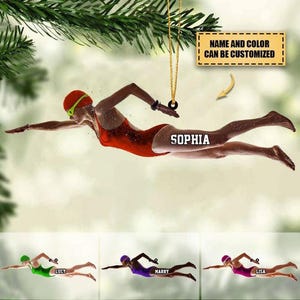Peut inclure: Ornement personnalisé représentant une nageuse en maillot de bain rouge, bonnet et lunettes. Le nom "SOPHIA" est affiché. Le texte "NAME AND COLOR CAN BE CUSTOMIZED" est également visible. D'autres nageurs sont présentés en bas.