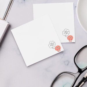 May include: Two white square sticky notes with a cartoon brain character and the text "Did you forget to use me today?" in a thought bubble. The brain is pink with red feet and eyes.