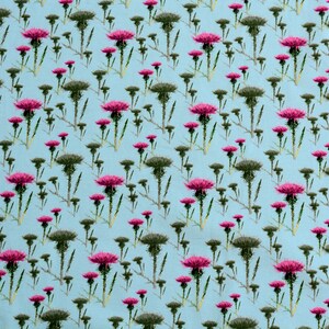 Puede incluir: Un patr&oacute;n repetido de cardos sobre un fondo azul claro. Los cardos tienen tallos y hojas verdes, con capullos verde oscuro y cabezas de flores de color rosa vibrante. El dise&ntilde;o est&aacute; espaciado uniformemente.