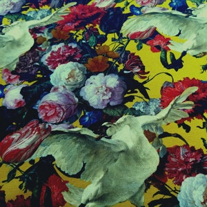 Puede incluir: Una tela amarilla con un patrón floral con pájaros blancos y flores de colores. La tela tiene una estética vintage.