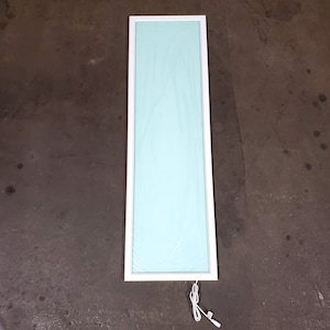 May include: A rectangular LED panel with a white frame and a light blue center. The panel is rectangular and has a white power cord attached. The panel is designed for use as a light source.