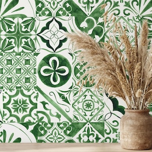 May include: A wall decorated with green and white patterned tiles. The tiles display floral and geometric designs. A vase of dried pampas grass is in front of the wall. The vase adds a natural element to the scene.