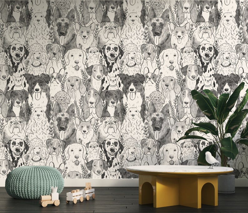 May include: A black and white wallpaper featuring a repeating pattern of various dog breeds. The wallpaper is displayed in a room with a light grey ottoman, a wooden toy train, and a yellow table with a white top.