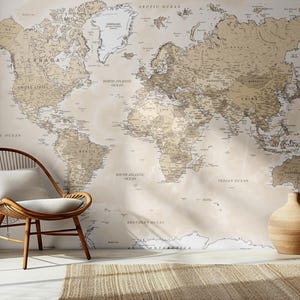 May include: A detailed world map in brown and beige tones is displayed on a wall. A wooden chair with a white cushion and a decorative vase are in front of the map. A woven rug is on the floor.