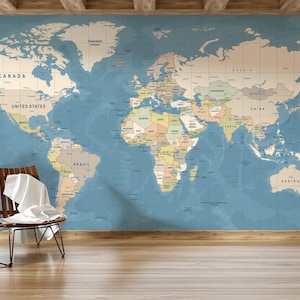 Puede incluir: Un gran mural de mapa del mundo en tonos apagados de azul, beige y verde domina la pared. El mapa está detallado con fronteras y nombres de países. Una silla de madera con un paño blanco y una bolsa de cuero están en primer plano.