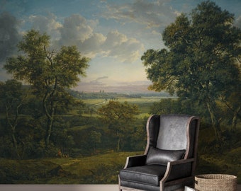 May include: A painting of a landscape with trees, a river, and a distant town. The painting is in a muted color palette of greens, browns, and blues. The painting is framed and hanging on a wall.