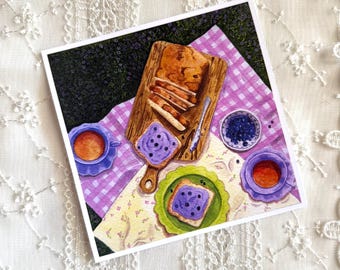 May include: A square art print featuring a watercolor illustration of a picnic scene. A wooden board holds sliced bread with blueberry spread, alongside two purple teacups, a small bowl of blueberries, and toast on a green plate, all on a purple gingham cloth.