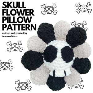 May include: A handmade skull-shaped pillow pattern with a flower design. The pillow is white with black accents, surrounded by black and beige yarn petals. The text "SKULL FLOWER PILLOW PATTERN" is displayed in large, bold letters.
