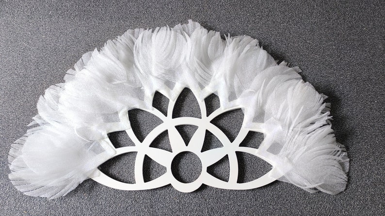 May include: White decorative wall hanging with a circular, geometric design and a fringe border.
