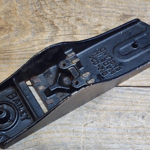 May include: Black metal hand plane with the text "BAILEY NO 4" and "MADE IN ENGLAND 012-202" on the top.