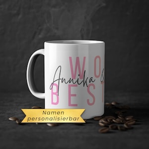 Könnte beinhalten: Eine weiße Keramik-Tasse mit schwarzem Henkel und dem Text "But first, coffee" in schwarzer, handschriftlicher Schrift. Die Tasse steht auf einer weißen Oberfläche.