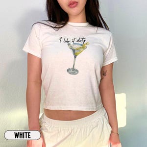 May include: White cropped t-shirt with the text "I like it dirty" and a martini glass graphic.
