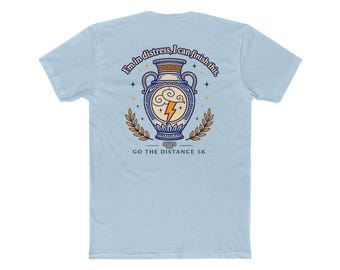 May include: A light blue t-shirt featuring a graphic on the back of a Greek-style vase with a lightning bolt and cloud design. The text reads "I'm in distress, I can finish this." and "GO THE DISTANCE 5K" with laurel branches on both sides.