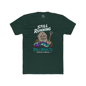 May include: A dark green t-shirt featuring a graphic with the text STILL RUNNING, DEAD TIRED, DIG & DASH 2026, and VIRTUAL 3-MILER. The design includes a tombstone, a shovel, a purple water bottle, and a pair of teal and purple running shoes.