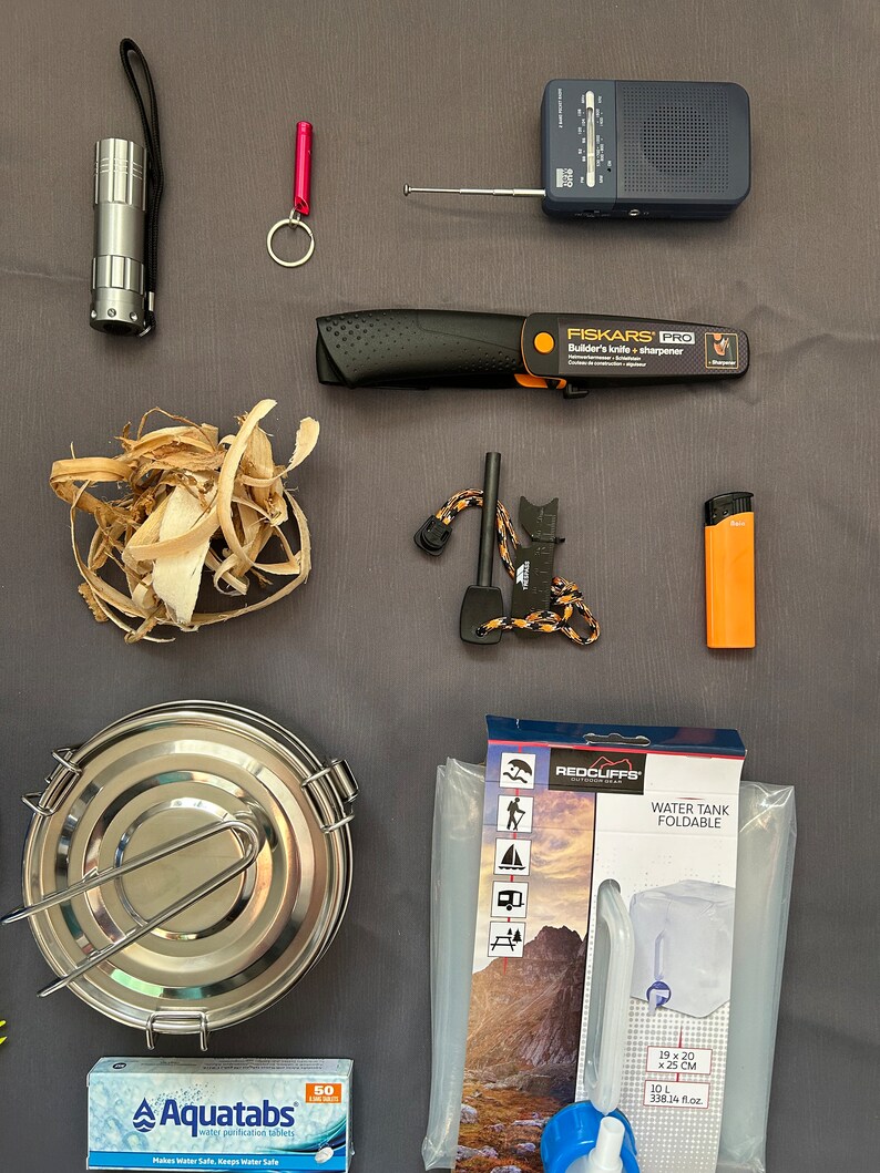 May include: A camping and survival kit with a variety of items, including a flashlight, a knife, a fire starter, a water purifier, a water tank, and a radio.