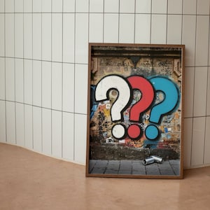 Könnte beinhalten: Ein gerahmter Druck einer Graffiti-Wand mit drei großen Fragezeichen, die in Weiß, Rot und Blau gestrichen sind. Die Fragezeichen befinden sich auf einer Backsteinmauer mit anderen Graffitis und Aufklebern.