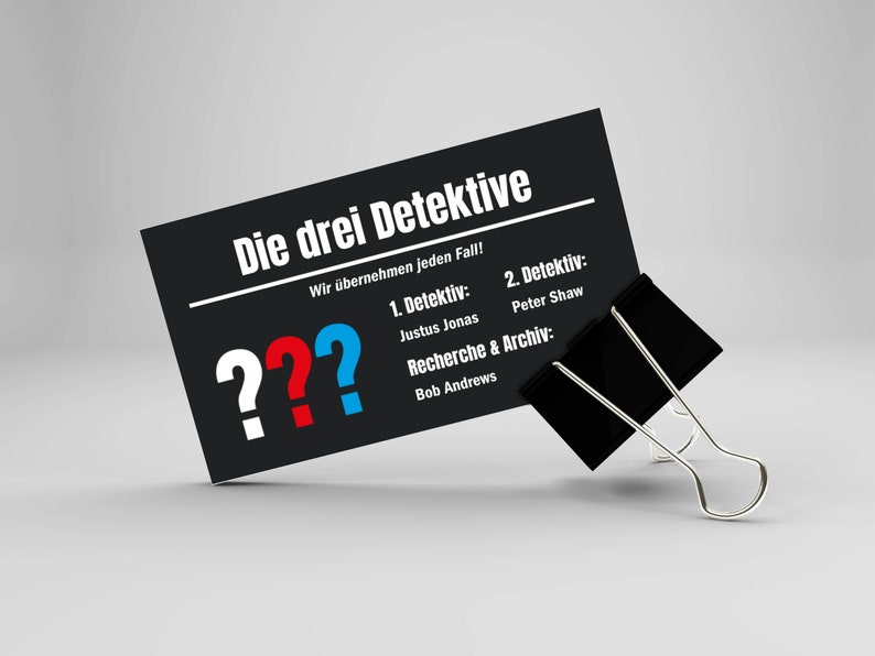 May include: A black and white business card with the text "Die drei Detektive" and the words "Wir &uuml;bernehmen jeden Fall!"  The card also lists the names of three detectives: Justus Jonas, Peter Shaw, and Bob Andrews.