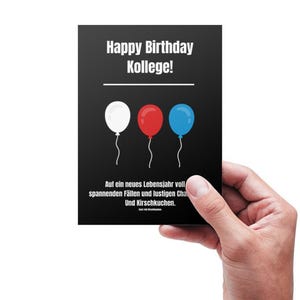 May include: A black card with the text "Happy Birthday Kollege!" and three balloons in the colors red, white, and blue. The text below the balloons reads "Auf ein neues Lebensjahr voll spannenden F&auml;llen und lustigen Chal und Kirschkuchen."