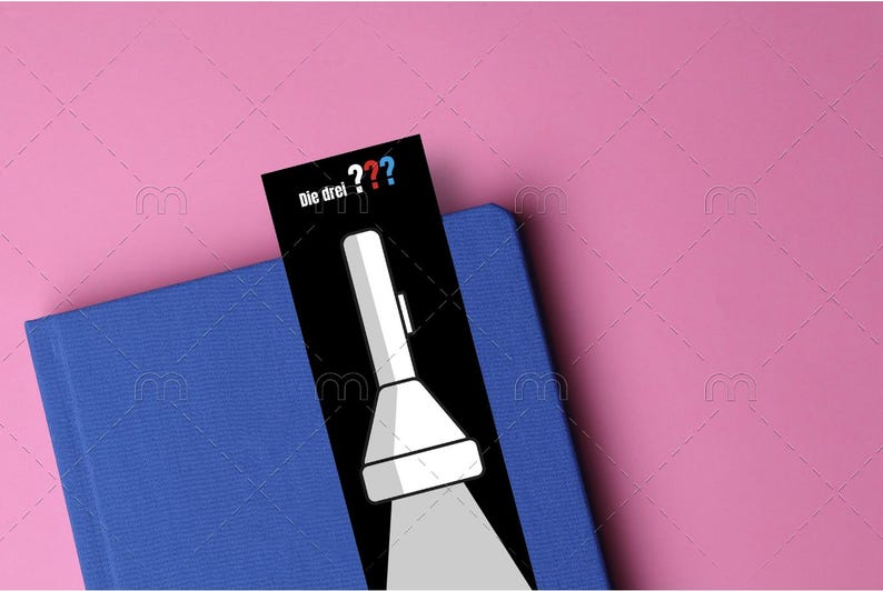 May include: A black bookmark with a white flashlight illustration and the text "Die drei ???" in German.