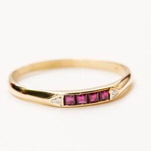 Peut inclure: Une bague en or avec une rangée de rubis rouges et deux petits diamants.