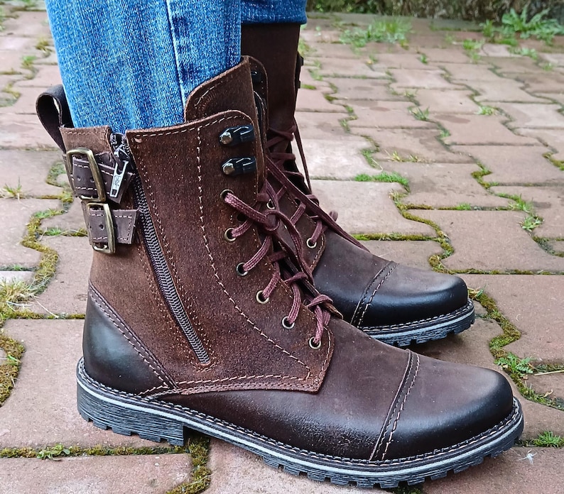 Close-up of the sleek metal side zipper on genuine leather ankle boots, highlighting fine craftsmanship and practical design.