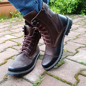 Close-up of the sleek metal side zipper on genuine leather ankle boots, highlighting fine craftsmanship and practical design.