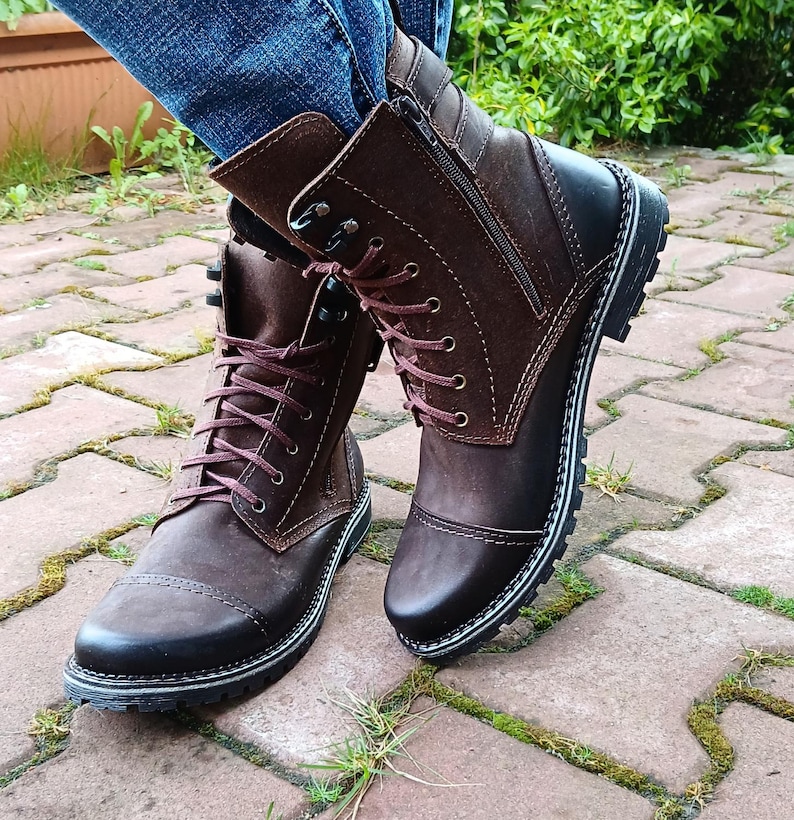 Close-up of the sleek metal side zipper on genuine leather ankle boots, highlighting fine craftsmanship and practical design.