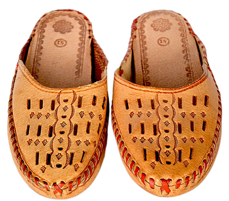May include: A pair of tan leather slippers with red stitching and a decorative pattern. The slippers have a pointed toe and an open back.