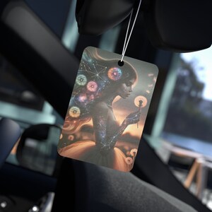 Puede incluir: Ambientador rectangular para coche con una mujer celestial con cabello de galaxia y un diente de le&oacute;n. La obra de arte incluye constelaciones y orbes coloridos. El ambientador est&aacute; colgado en un coche.