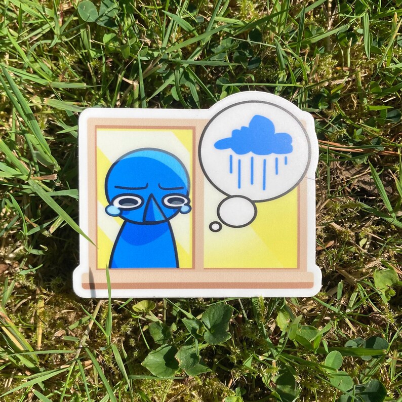 Pu&ograve; includere: Un adesivo raffigurante una figura blu con un'espressione triste all'interno di una cornice gialla. Una nuvoletta mostra una nuvola di pioggia blu. L'adesivo &egrave; sull'erba verde.