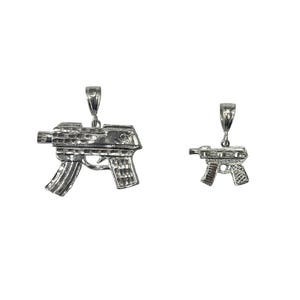 May include: Two silver gun pendants, one larger than the other, with a detailed design.