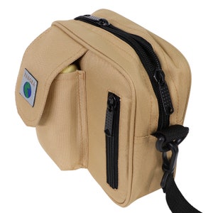 May include: A tan canvas crossbody bag with black zips and a black strap. The bag has a large front pocket with the word "PANGEA" and a globe logo.
