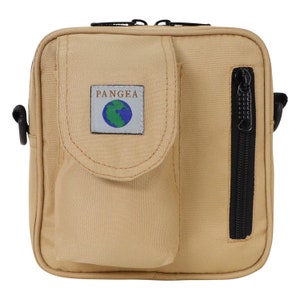 May include: A tan canvas crossbody bag with a zipped pocket on the front. The bag has a black zipper and a black strap. The bag has a patch on the front that says "PANGEA" with a globe logo.