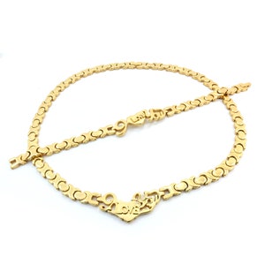 May include: A gold-tone necklace and bracelet set with a heart-shaped pendant that says "Love You".