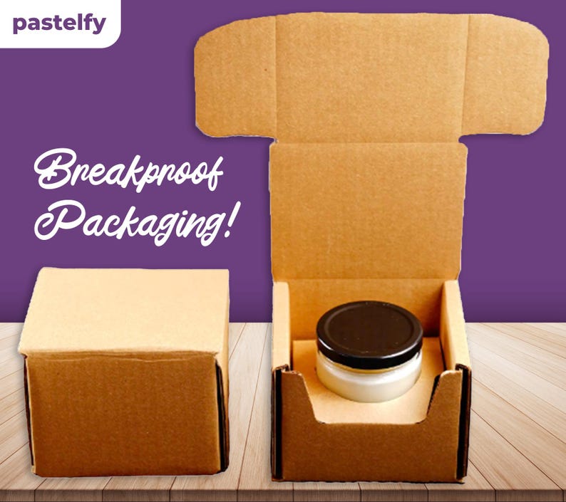 May include: Two brown cardboard boxes, one open and one closed. The open box has a black lidded jar inside. The closed box is on a wooden surface. The text "Breakproof Packaging!" is printed on the background.
