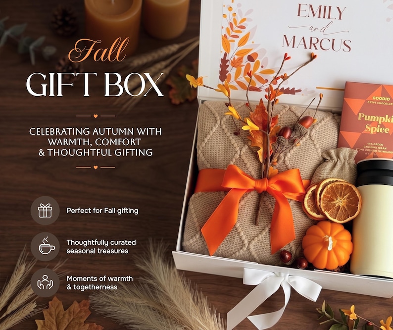 May include: A white gift box containing a beige cable-knit blanket tied with an orange ribbon, a small orange pumpkin, dried orange slices, a small burlap pouch, and a bar of Pumpkin Spice chocolate, with text reading EMILY and MARCUS.