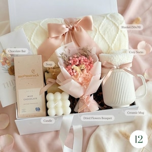 Cozy hygge gift basket with dried flower bouquet, candle, hand cream, 
ceramic mug, and gold spoon — thoughtful birthday or anniversary gift