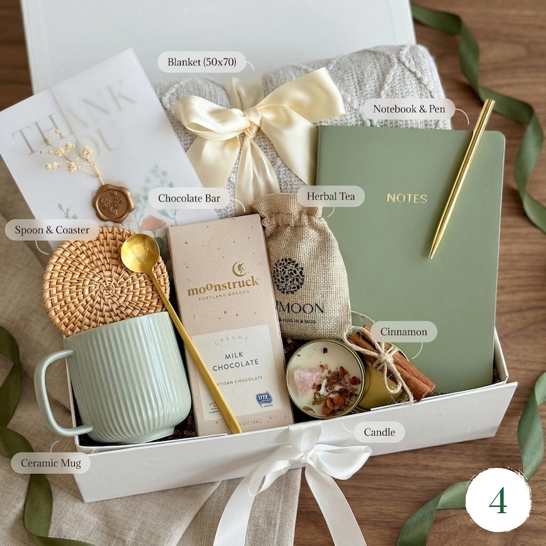 May include: A gift box filled with a ceramic mug, chocolate bar, herbal tea, candle, notebook, pen, and a blanket (50x70 inches). The box is tied with a white ribbon and includes a spoon, coaster, and cinnamon sticks.