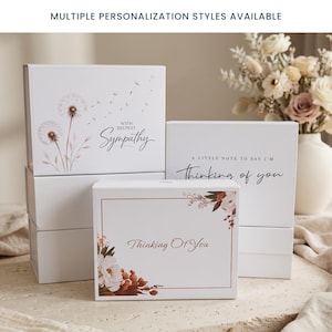May include: Three white rectangular gift boxes with magnetic closures. One box features a dandelion illustration and the text With Deepest Sympathy. Another box displays the text A Little Note To Say I'm Thinking of you. The third box has floral art.