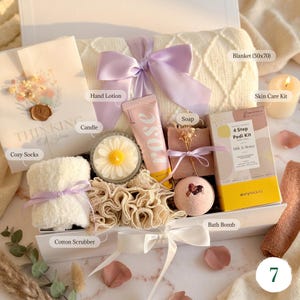 Lavender hygge gift basket with cozy blanket, dried flower bouquet, hand 
lotion, candle, and skin care kit — luxurious spa gift for her