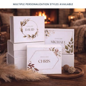 May include: White gift boxes with personalized names and floral designs. The boxes feature names like "DAVID", "MICHAEL", and "CHRIS" with decorative botanical elements. The text "MULTIPLE PERSONALIZATION STYLES AVAILABLE" is at the top.