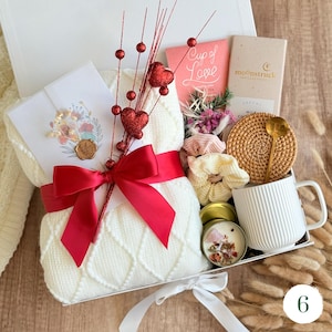Gift box with dried roses, cozy blanket, chocolate, 
and ceramic mug — romantic I love you gift for wife or girlfriend